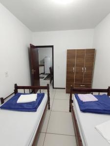 2 Betten in einem Zimmer mit Spiegel in der Unterkunft Apartamento de hospedagem-calendula in Joinville