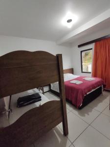 ein Schlafzimmer mit einem Etagenbett mit einer roten Decke in der Unterkunft Apartamento de hospedagem-calendula in Joinville