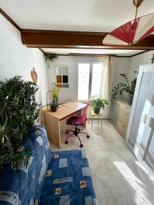 Cette chambre dispose d'un bureau et d'une table avec des plantes. dans l'établissement Cozy Room in an old Farmhouse near Vaduz, à Sevelen