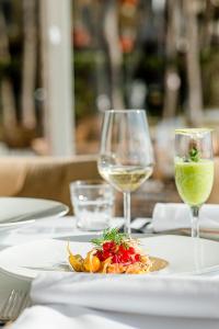 Diamma Resort Conference & Spa في دوريس: طاولة مع طبق من الطعام وكأسين من النبيذ