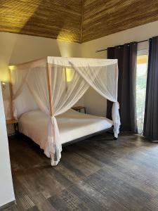 ein Schlafzimmer mit einem Himmelbett in der Unterkunft CASA COCO II in Nianing