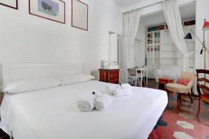 een slaapkamer met een wit bed en handdoeken bij Charming Colosseum in Rome