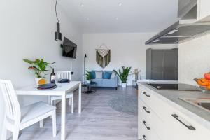 a kitchen with a white table and a white counter top at Elegant Fully Equipped Apartment near City Centre in Heraklio Town