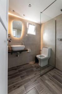 a bathroom with a sink and a toilet and a mirror at Elegant Fully Equipped Apartment near City Centre in Heraklio