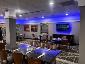 a dining room with tables and chairs and a tv at Holiday Inn Hotel & Suites Springfield, an IHG Hotel in Springfield