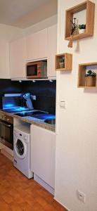 una cucina con lavandino e lavatrice di Studio vue mer. Calme et idéalement situé a Canet-en-Roussillon