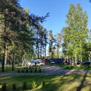 uma vista para um parque com uma casa e árvores em Hotelli Hirsiranta em Ruokolahti