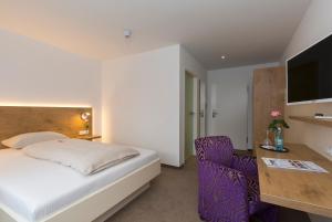 ein Schlafzimmer mit einem Bett, einem Schreibtisch und einem Stuhl in der Unterkunft Hotel Hirsch in Leonberg + 62 Fotos