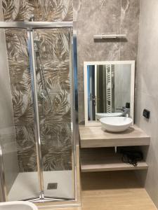 La salle de bains est pourvue d'une douche, d'un lavabo et d'un miroir. dans l'établissement B&B Il Viaggiatore, à Marina di Massa