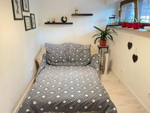 un letto in una camera con cuscino e piante di Gemütliches Zimmer in ruhiger Wohngegend a Markkleeberg