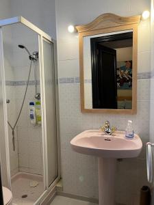 a bathroom with a sink and a shower with a mirror at Vigo Excursions in Vigo