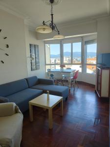 a living room with a blue couch and a table at Vigo Excursions in Vigo