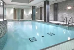 - une grande piscine d'eau bleue dans un bâtiment dans l'établissement Luxurious Condominium near Celebration Square, à Mississauga