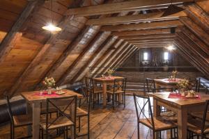 restauracja z drewnianymi stołami i krzesłami na poddaszu w obiekcie Penzion Ve stoleti w mieście Loděnice