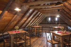 a restaurant with wooden tables and chairs in a attic at Penzion Ve stoleti in Loděnice