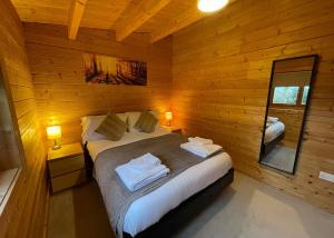 WinshamにあるOathill Farm Lodgesの木製の壁のベッドルーム1室