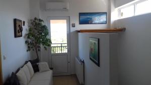 a living room with a white couch and a window at Manolo s olive farm, apartment with seaview in Chania Town