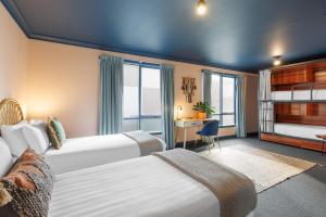 a hotel room with two beds and a desk at Roamer St Kilda - formerly Selina St Kilda Melbourne in Melbourne