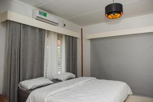a bedroom with a bed and a window at Anna Beach Village in Ponta do Ouro