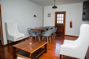 a living room with a table and white chairs at Anna Beach Village in Ponta do Ouro