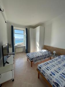a bedroom with two beds and a view of the ocean at CasAmare di Carla in Savona