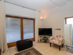 a living room with a tv and a chair at The Coach House in Tewkesbury