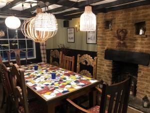 uma sala de jantar com uma mesa e lustres em The Lethbridge Arms em Taunton