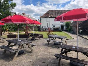 a group of picnic tables with red umbrellas at The Lethbridge Arms in Taunton