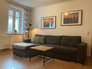 a living room with a couch and a table at FeWo "Biela", gemütlich, zentral, ruhig, Terrasse, Sandstein-Ferien, Familienfreundl in Königstein an der Elbe