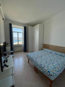 um quarto com uma cama, uma secretária e uma janela em CasAmare di Carla em Savona