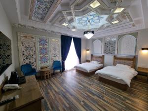 a bedroom with two beds and a coffered ceiling at Latifa Begim Boutique Hotel in Bukhara