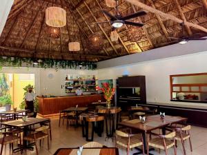 a restaurant with tables and chairs and a ceiling at Hotel Chablis Palenque in Palenque