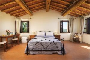 a bedroom with a bed in a room with wooden ceilings at Agriturismo La Casellina in Monticchiello