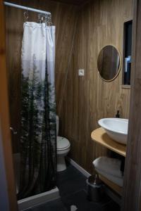 a bathroom with a shower curtain with a forest at Casuta Mea in Piatra Neamţ