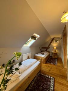 a attic bedroom with two beds and a window at Villa Landidyll mit separatem Wellness-Bereich in Joachimsthal