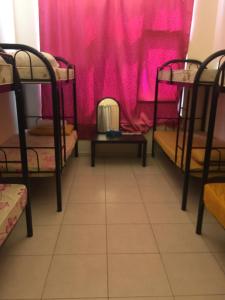 a room with bunk beds in front of a pink curtain at Woman ONLY-AnaRuby Backpackers-Mashreq Metro Station in Dubai
