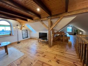 una gran sala de estar con suelo de madera y techos abovedados. en Villa Landidyll mit separatem Wellness-Bereich, en Joachimsthal