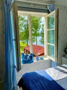 a bedroom with a bed and a window with a view at Villa Fryksta in Kil
