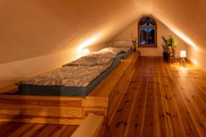 a bedroom with a bed on a wooden floor at Villa Landidyll mit separatem Wellness-Bereich in Joachimsthal