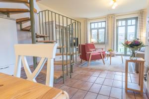 a living room with stairs and a table and chairs at Ferienhaussiedlung Strandperlen Buchenhof 2c (Typ II) in Wustrow