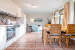 a kitchen and dining room with a table and chairs at Ferienhaussiedlung Strandperlen Buchenhof 2d (Typ I) in Wustrow