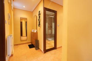 um corredor com uma casa de banho com um chuveiro e um espelho em MyHouseSpain - Apartamento 2 habitaciones cerca de la playa em Gijón