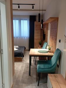 a room with a table and chairs and a bed at Ru&Ki apartman- Hotel Djina A13 in Kopaonik