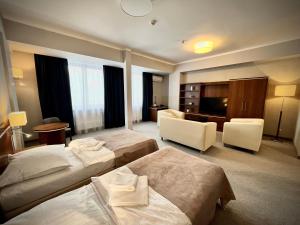 a hotel room with two beds and a desk at Hotel Szyndzielnia in Bielsko-Biała