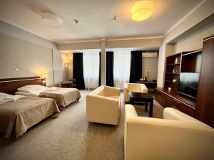 ein Hotelzimmer mit zwei Betten und einem Fernseher in der Unterkunft Hotel Szyndzielnia in Bielsko-Biała