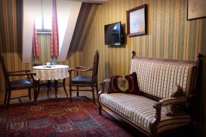 ein Wohnzimmer mit einem Tisch, einem Sofa und einem TV in der Unterkunft Austeria Klezmer Hois in Krakau