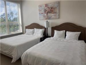 a bedroom with two beds with white sheets and a window at Resort Style Apartments in Spring, TX in Spring