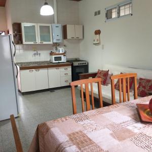 a kitchen with a table and two chairs and a refrigerator at La casita in Paraná