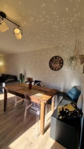 een woonkamer met een houten tafel en een bank bij Charmante petite maison sur le port du légué in Plérin