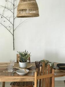 a dining room table with a potted plant on it at Wabi-Sabi Guesthouse At Ipoh Town 侘寂风民宿 in Ipoh